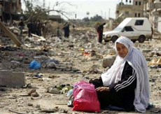 Một phụ nữ Palestine thu lượm đồ đạc sau khi ngôi nhà của bà tại Gaza bị phá hủy vào ngày 9/1 trong một đợt không kích của Israel.